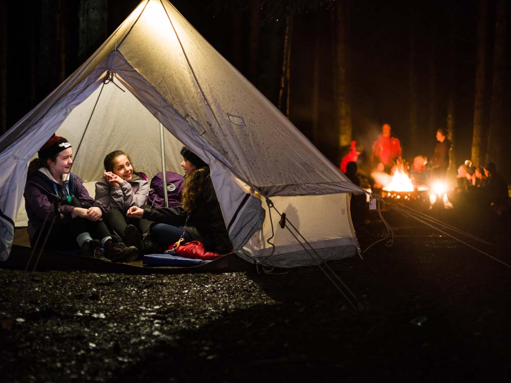 three-female-cubs-in-tent-with-campfire-jpg